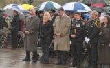 2012 Memorial Service - guests paying respects at memorial service in the rain with umbrellas