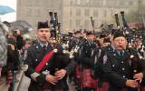 2012 Memorial Service - Officers with bagpipes marching in front of onlookers