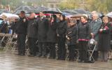2012 Memorial Service - guests paying respects at memorial service in the rain with umbrellas (3)