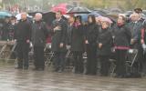 2012 Memorial Service - guests paying respects at memorial service in the rain with umbrellas (5)